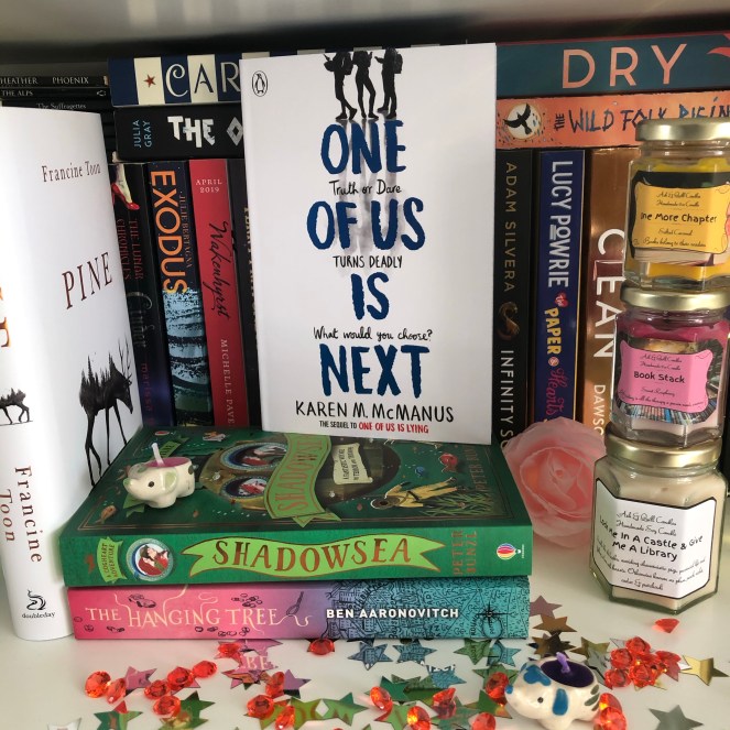 Book shelf, prominently featuring a book titled: One Of Us Is Next