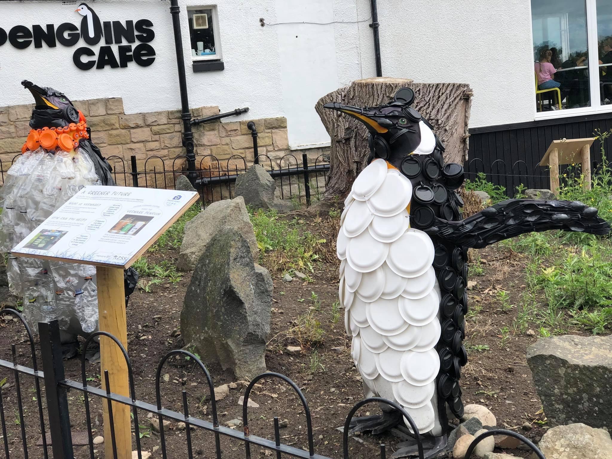 A pair of penguins made of recyclable material stand outside the Penguin Cafe at Edinburgh Zoo.